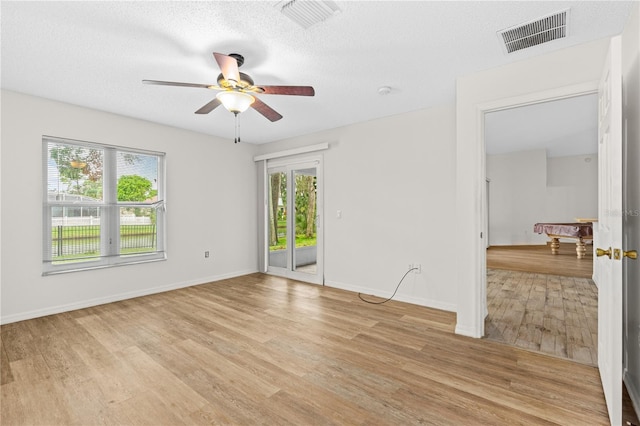 unfurnished room with ceiling fan, light hardwood / wood-style flooring, a textured ceiling, and pool table