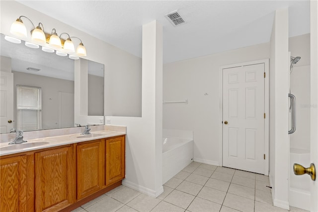 bathroom with vanity, tiled bath, and tile patterned floors