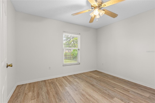 spare room with ceiling fan, light hardwood / wood-style flooring, and a textured ceiling