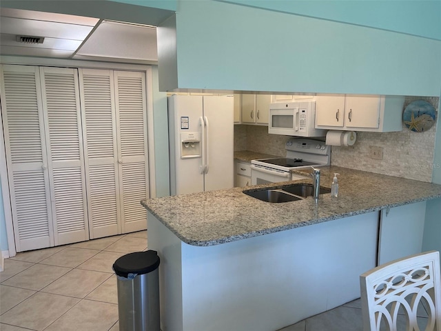 kitchen with white cabinets, light tile patterned flooring, white appliances, and kitchen peninsula