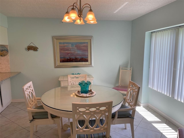 dining area featuring a notable chandelier, light tile patterned floors, and a textured ceiling