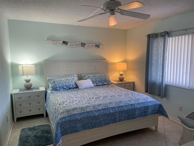 tiled bedroom with ceiling fan and a textured ceiling