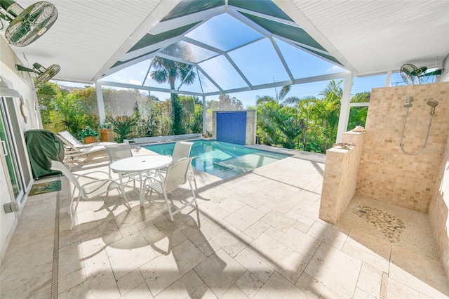 view of pool with glass enclosure and a patio area