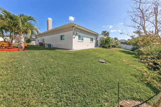 view of side of home featuring a lawn and central AC unit