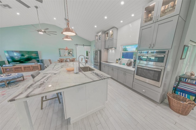 kitchen featuring gray cabinets, a kitchen breakfast bar, a barn door, and sink