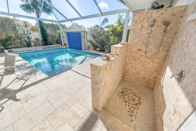 view of pool with glass enclosure and a patio area