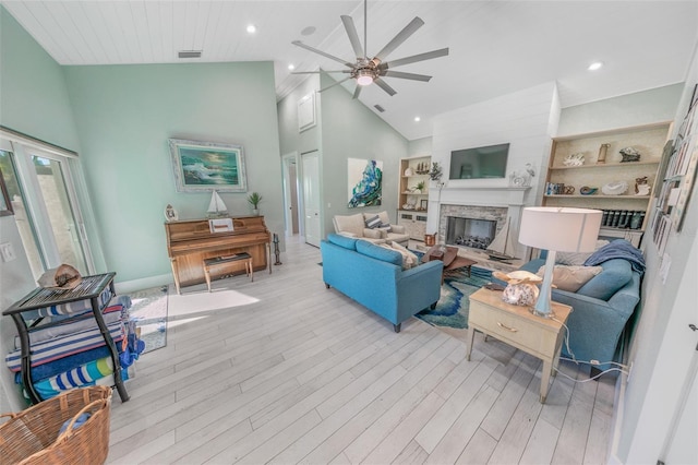 living room featuring ceiling fan, built in features, light wood-type flooring, and high vaulted ceiling