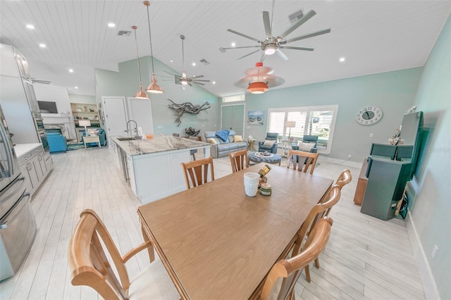 dining area featuring high vaulted ceiling, light wood-type flooring, sink, and wood ceiling