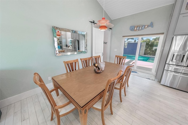 dining area with light hardwood / wood-style flooring and lofted ceiling