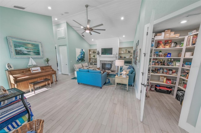 living room featuring ceiling fan, high vaulted ceiling, and light hardwood / wood-style flooring