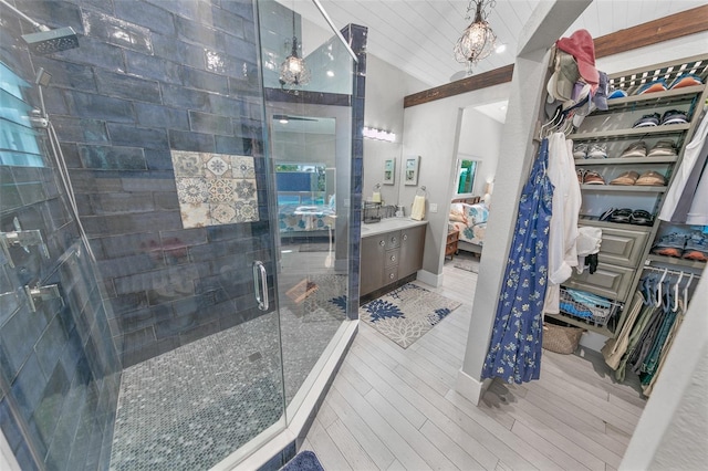 bathroom with vanity, a shower with shower door, and lofted ceiling