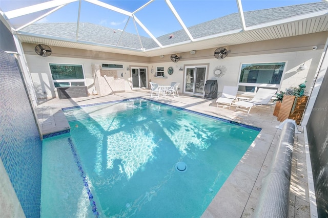 view of swimming pool with glass enclosure, a patio, and french doors