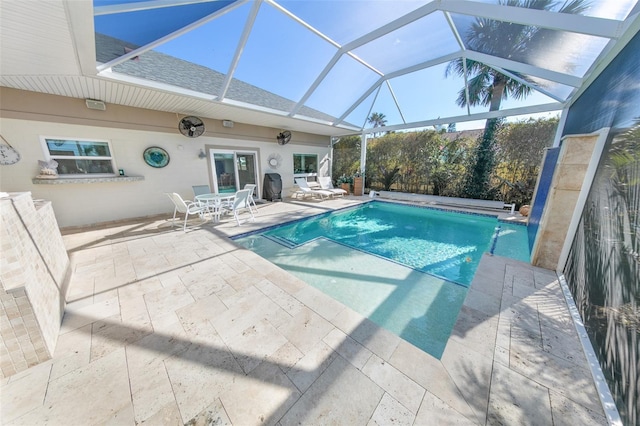 view of pool with glass enclosure and a patio