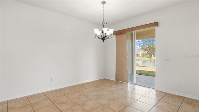 empty room with a water view, light tile patterned floors, and an inviting chandelier