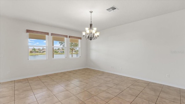 tiled empty room with a water view and a notable chandelier