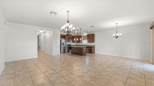 kitchen with a kitchen island, an inviting chandelier, hanging light fixtures, and appliances with stainless steel finishes