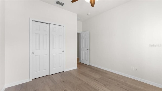 unfurnished bedroom featuring ceiling fan, a closet, and light wood-type flooring