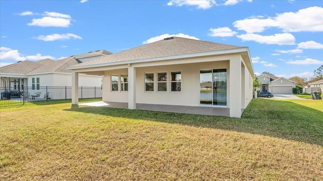 back of property with a yard and a patio