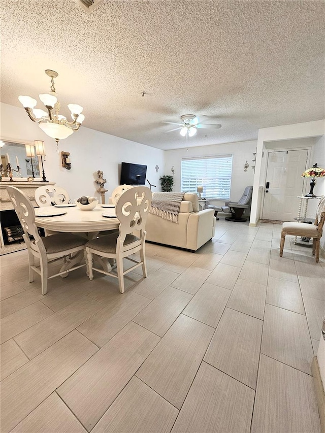 dining room featuring a textured ceiling and ceiling fan with notable chandelier