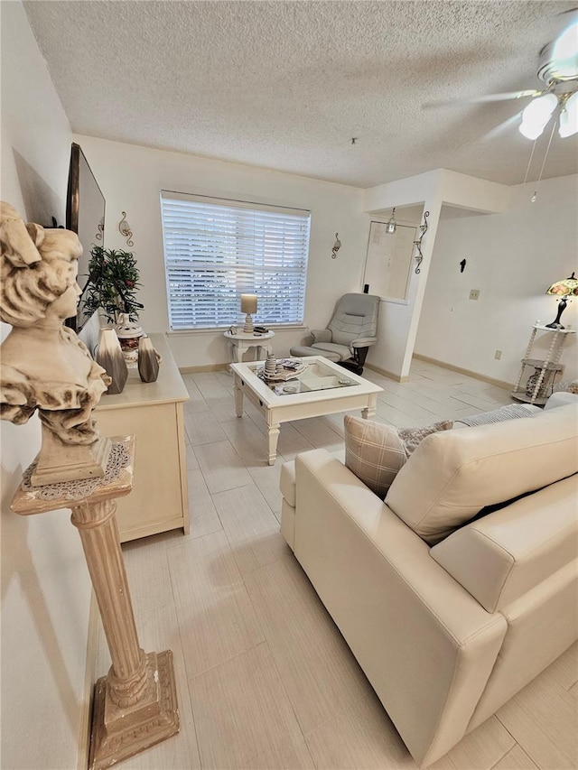 living room with ceiling fan and a textured ceiling