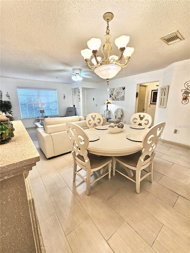 dining space featuring a textured ceiling, ceiling fan with notable chandelier, and light wood-type flooring