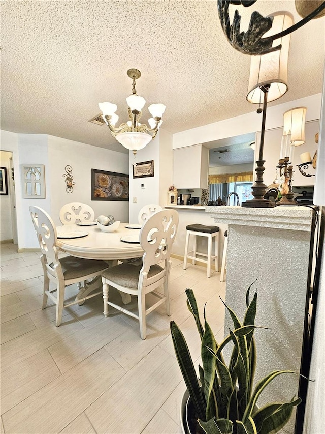 dining room with a textured ceiling and an inviting chandelier