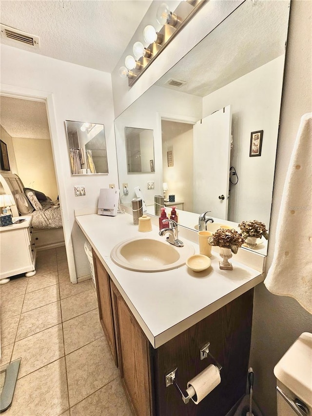 bathroom with vanity, a textured ceiling, and tile patterned floors