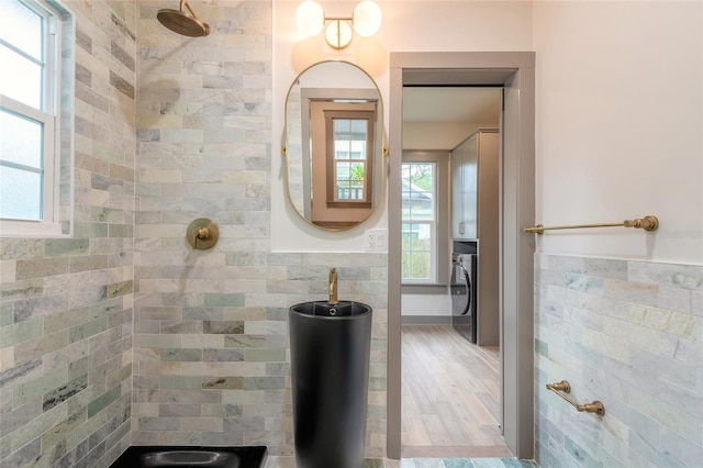 bathroom featuring tiled shower and washer / dryer