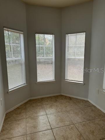 tiled spare room with a healthy amount of sunlight