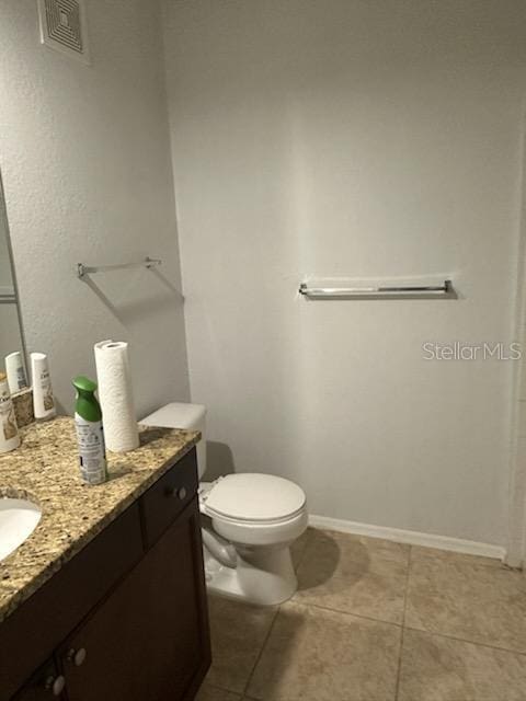 bathroom with tile patterned flooring, vanity, and toilet