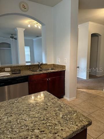 kitchen with light stone counters, stainless steel dishwasher, ornamental molding, sink, and light tile patterned floors