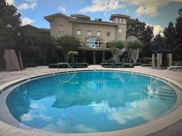 view of swimming pool with a gazebo and a patio area