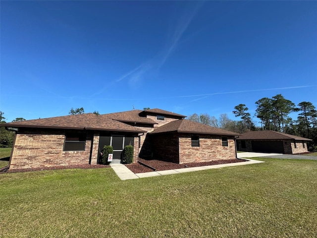 rear view of property with a lawn, brick siding, and a shingled roof