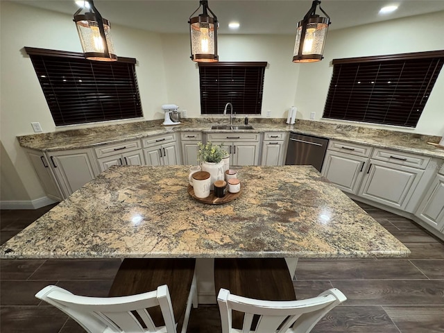 kitchen with pendant lighting, sink, white cabinets, and dishwasher