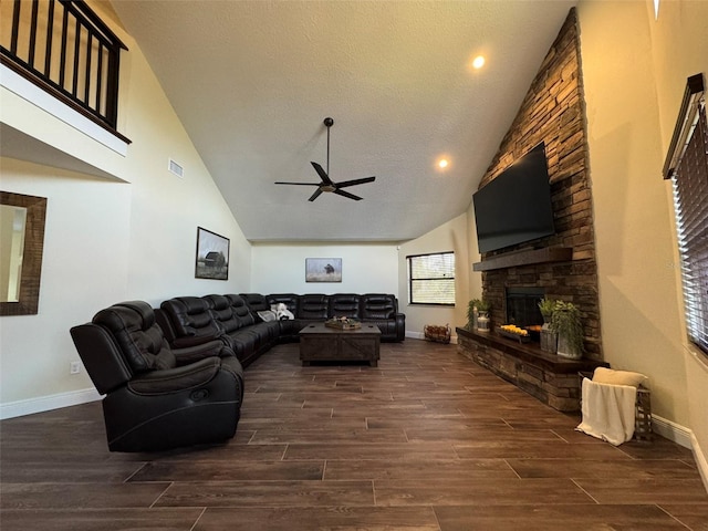 living room with a textured ceiling, a fireplace, ceiling fan, and vaulted ceiling