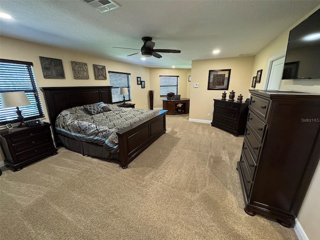 bedroom with light colored carpet, a textured ceiling, and ceiling fan