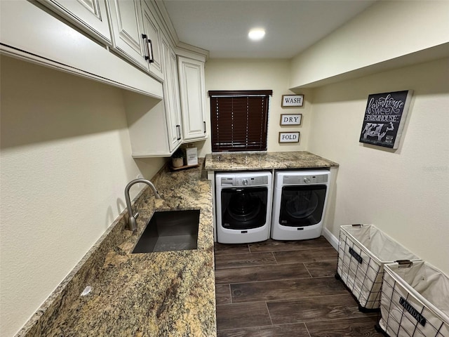 laundry room featuring separate washer and dryer, sink, and cabinets