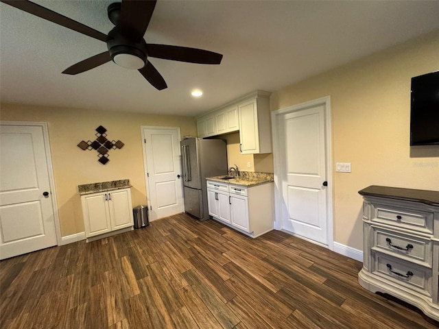 kitchen with sink, stainless steel refrigerator, dark hardwood / wood-style flooring, ceiling fan, and white cabinets