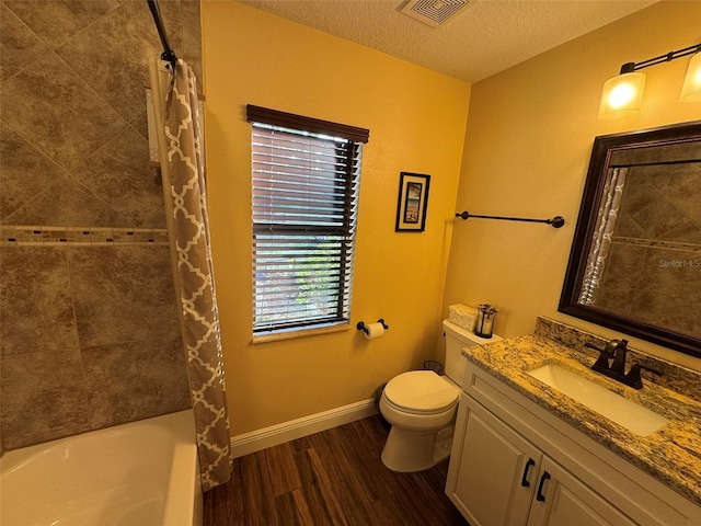 full bathroom featuring shower / tub combo with curtain, vanity, wood-type flooring, a textured ceiling, and toilet