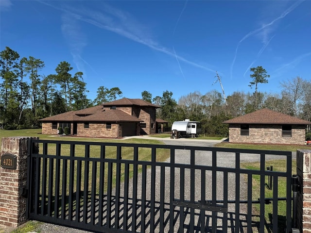 view of gate with a fenced front yard and a lawn