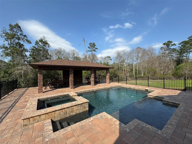 view of swimming pool with a gazebo, a pool with connected hot tub, a patio, and fence