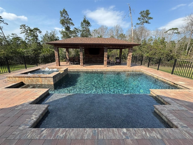 view of swimming pool with a patio area, a pool with connected hot tub, and a fenced backyard