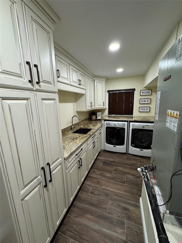 laundry area with recessed lighting, independent washer and dryer, wood tiled floor, and a sink