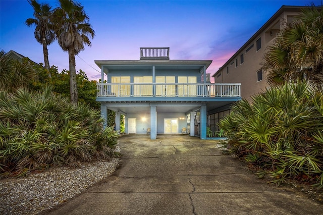 coastal inspired home featuring a balcony and a carport