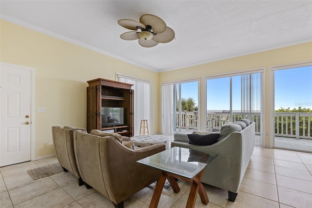 living room featuring ceiling fan, crown molding, light tile patterned floors, and a textured ceiling