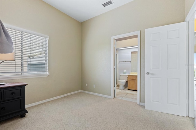 unfurnished bedroom featuring connected bathroom, a spacious closet, and light colored carpet