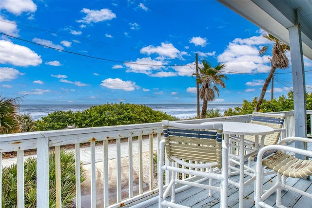 balcony featuring a beach view and a water view