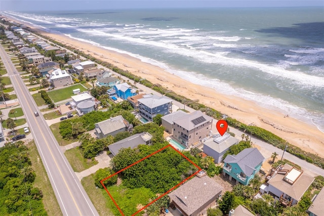 aerial view with a water view and a beach view