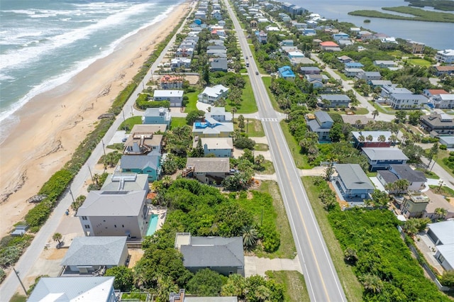 birds eye view of property featuring a water view and a beach view