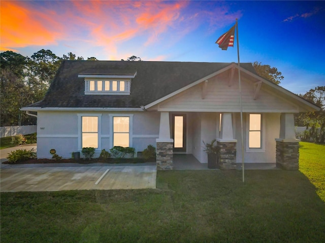 view of front of house with a lawn and a porch